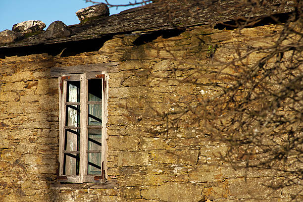 istock Old stone house and broken window at dusk. 484239714