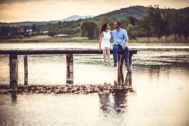 istock Couple sitting on jetty 484251988