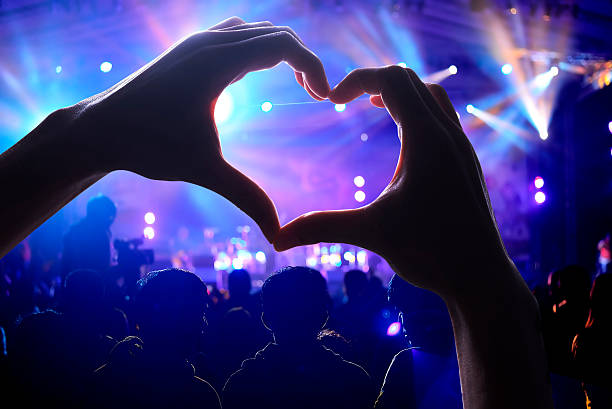 Crowd of Audience at concert Crowd of Audience at during a concert with a heart shaped hands shadow classical concert photos stock pictures, royalty-free photos & images