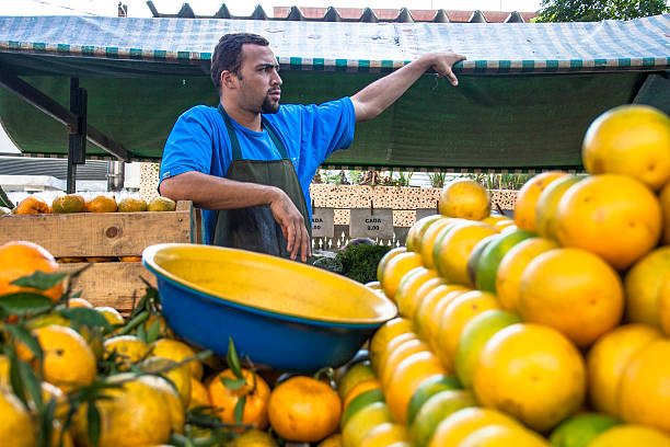 Sao Paulo, Brazil, June 05, 2008. Man selling orange fruits at a street market in Sao Paulo