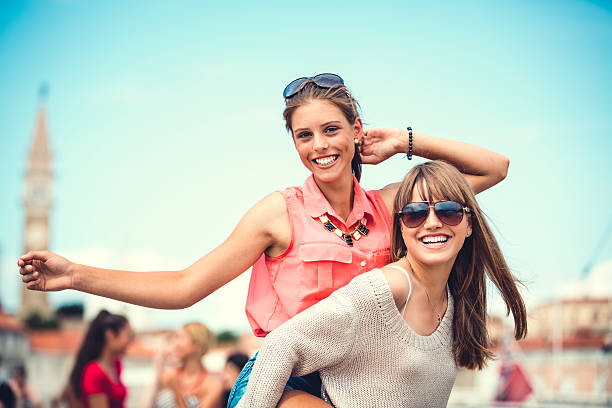 Portrait of two teenagers girls with long hair and piercing smiling outdoor