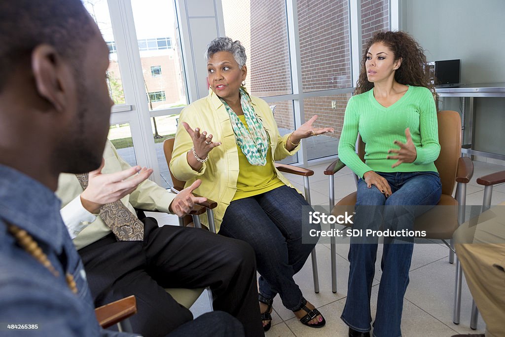 Senior adult woman talking to support or discussion group Senior adult woman talking to support or discussion group. 30-39 Years Stock Photo