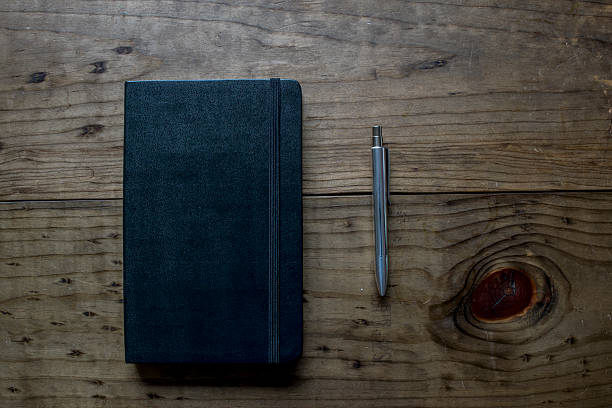 istock Leather Notebook with Silver Pen on a wooden table 484265556