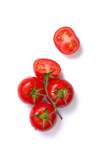 Top view of fresh tomatoes, whole and half cut, isolated on white background