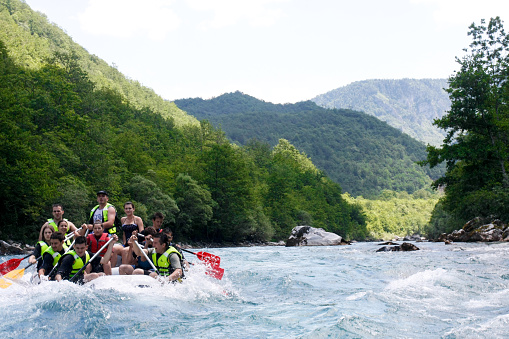 Tara, Montenegro - June 19th, 2009: A group of young tourists and adventurists enjoy white water rafting on river Tara in Montenegro, which is extremely popular during spring.