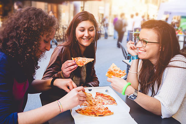 istock Friends eating Pizza on the streets 484266439