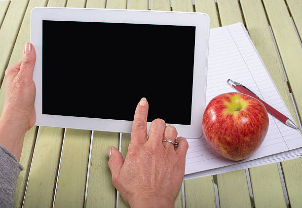 istock Woman holding a tablet computer with an apple 484266465