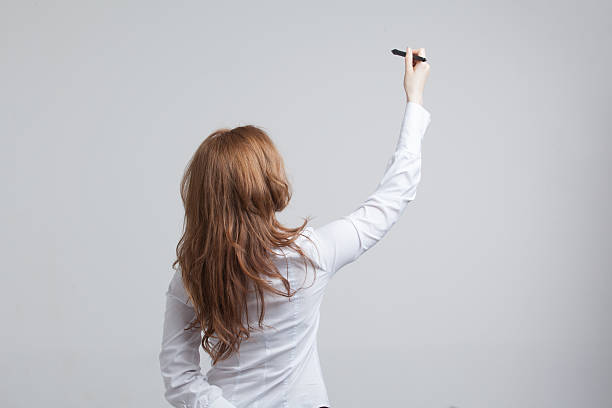 istock young woman with pen on grey background 484266738