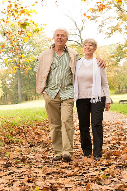 istock Senior Couple Walking In Park 484268801