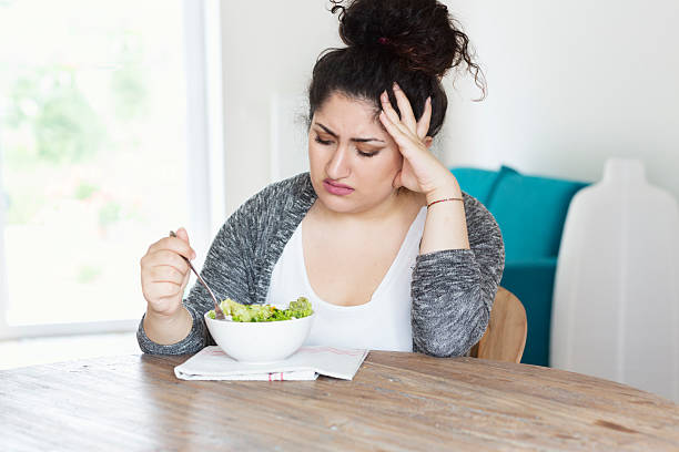 istock young hispanic woman diet eating salad unhappy 484270106