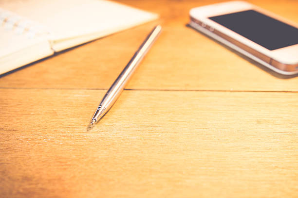 istock Pen and book on wooden table, style vintage. 484271746