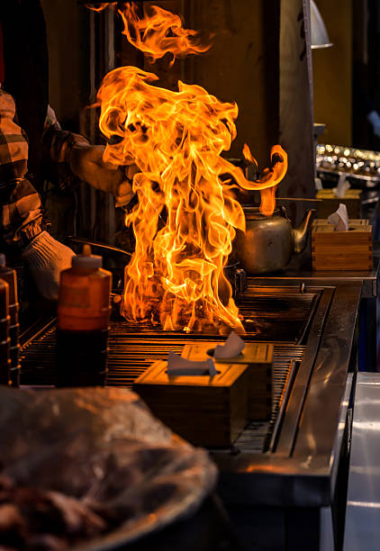 chef grilling bbq with flame of burning in restaurant
