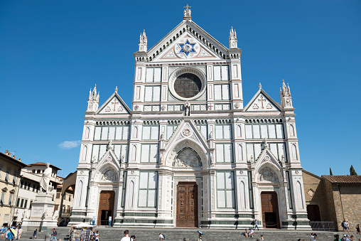Florence, Italy - July 30, 2015: People walk nearby Basilica of Santa Croce in Piazza Santa Croce during a hot summer day. Basilica of Santa Croce is the principal Franciscan church in Florence and a minor basilica of the Roman Catholic Church.