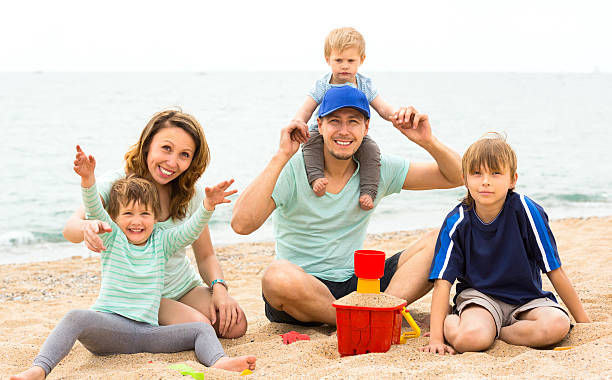 istock parents with  children playing on the coast 484286134