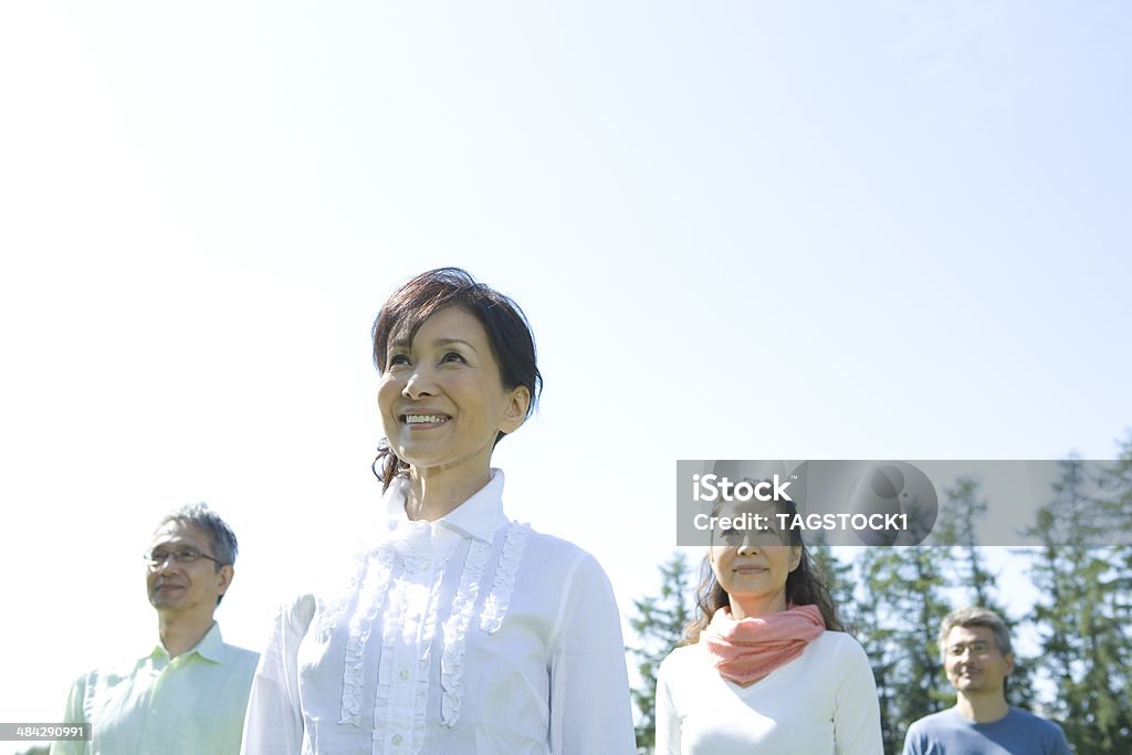 Two senior couples standing still under blue sky - 로열티 프리 위를 보기 스톡 사진
