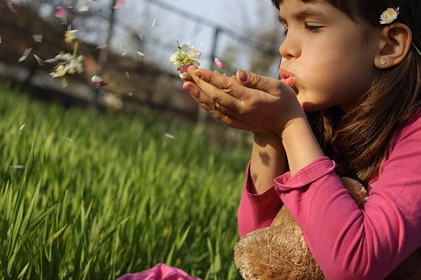 istock Girl blowing little flowers 484291195