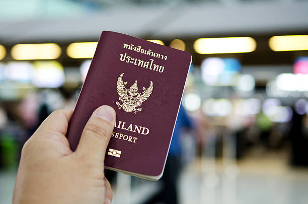 istock hand holding thailand passport 484291393