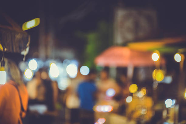 Timelapse of unidentified tourists walk along walking street. Blurred bokeh background