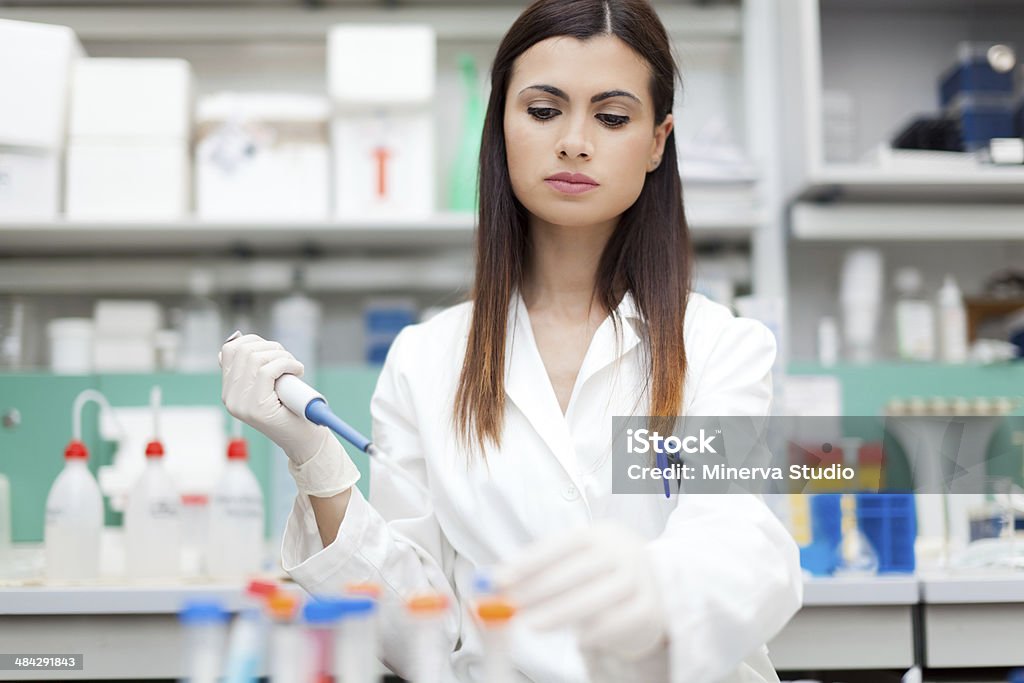 Researcher examining a test tube Researcher working in a laboratory Adult Stock Photo