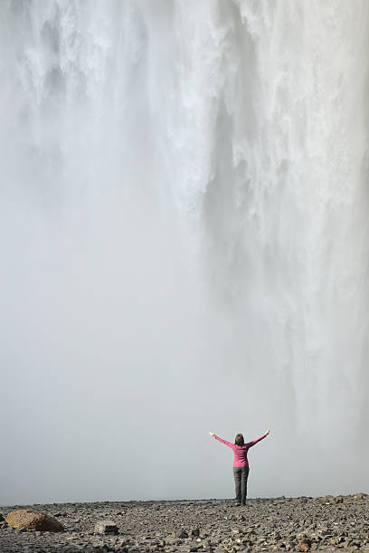 istock Glorious Waterfall - Woman With Arms Raised By Giant Cascade 484292228
