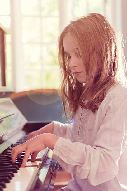 istock Young Girl Playing Piano In a Sunlight Room 484295494
