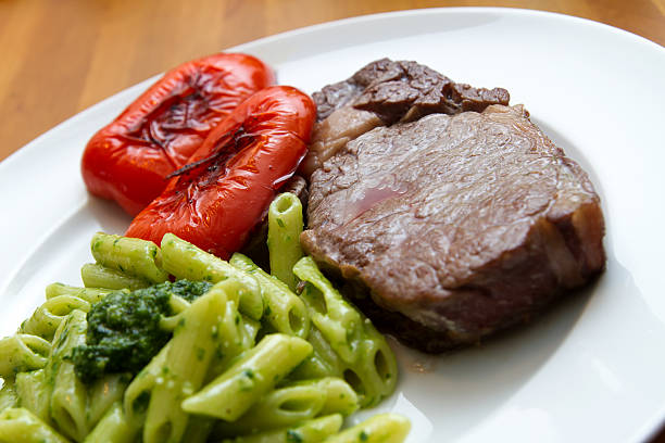 Steak with baerlauchpesto, pasta and peppers Steak with baerlauch pesto, pasta and bell pepper zigeunerlauch stock pictures, royalty-free photos & images