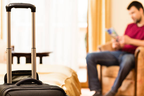 Man and his luggage in hotel room