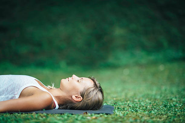 Yoga Shavasana Girl doing yoga, meditating, Shavasana or corpse position lying on back stock pictures, royalty-free photos & images