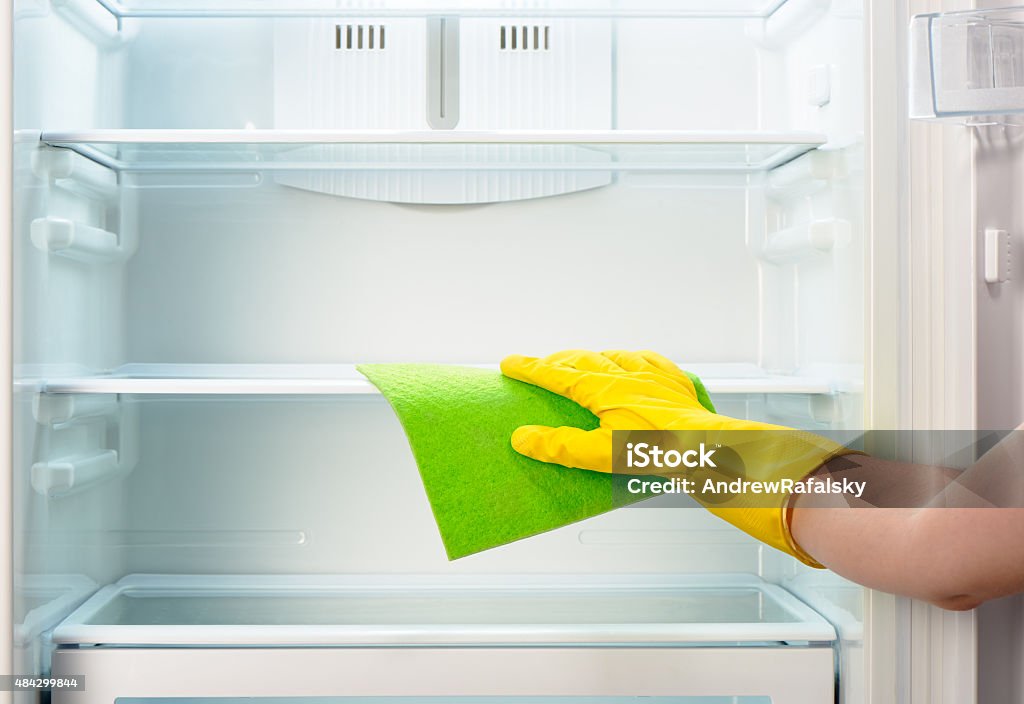 Woman's hand mit gelbe Handschuhe Reinigung Lappen Kühlschrank mit Grün - Lizenzfrei 2015 Stock-Foto