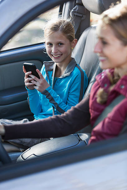 istock Little girl texting while mother drives 484302954