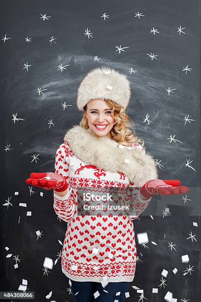 Happy Blonde Woman In Winter Outfit Against Blackboard Stock Photo - Download Image Now