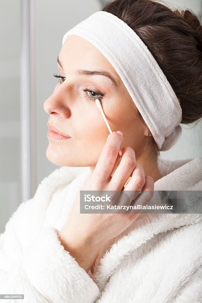 Woman removing make-up Woman in white bathrobe removing make-up Adult Stock Photo