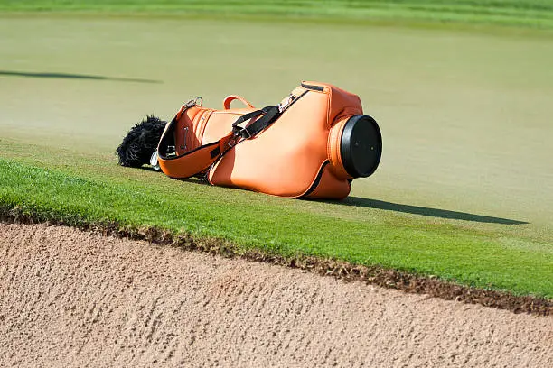 orange golfbag near the green at a golfcourse