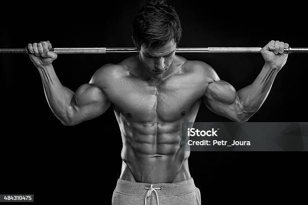 Muscoloso Bodybuilder Guy Facendo Esercizi Con Manubri - Fotografie stock e altre immagini di Abbronzatura