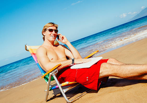 istock Casual Businessman Relaxing at the Beach with Laptop Computer Ta 484312667
