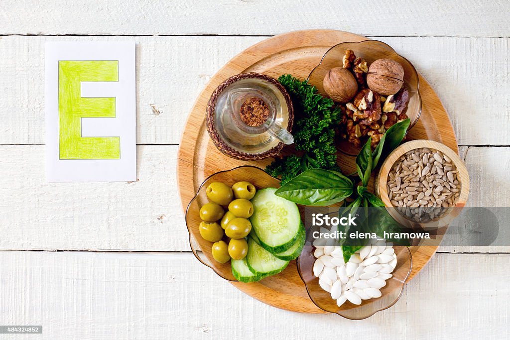 Foods containing vitamin E Foods containing vitamin E: walnuts, sunflower seeds, sunflower oil, herbs, pumpkin seeds, olives, cucumbers 2015 Stock Photo