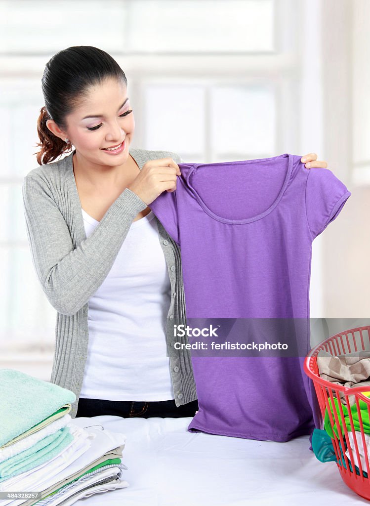 laundry at home Pretty young woman doing the laundry at home Adult Stock Photo