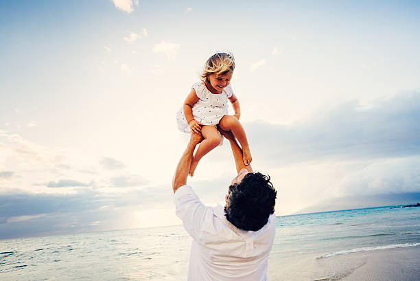 istock Father and Daughter Playing Together at the Beach at Sunset 484328679