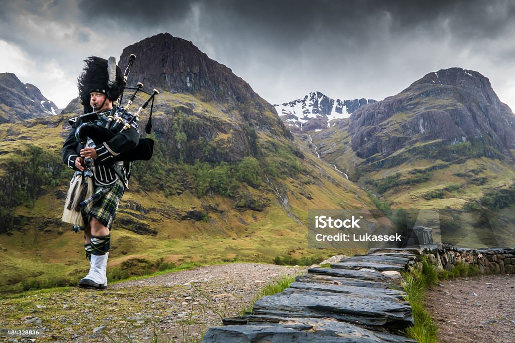 Traditional bagpiper in the scottish highlands by Glencoe Bagpipe Stock Photo