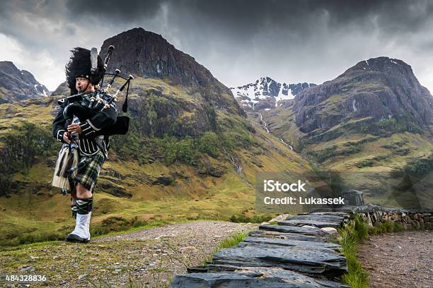 Traditional Bagpiper In The Scottish Highlands By Glencoe Stock Photo - Download Image Now