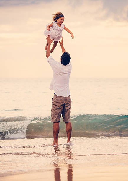 istock Father and Daughter Playing Together at the Beach at Sunset 484328925