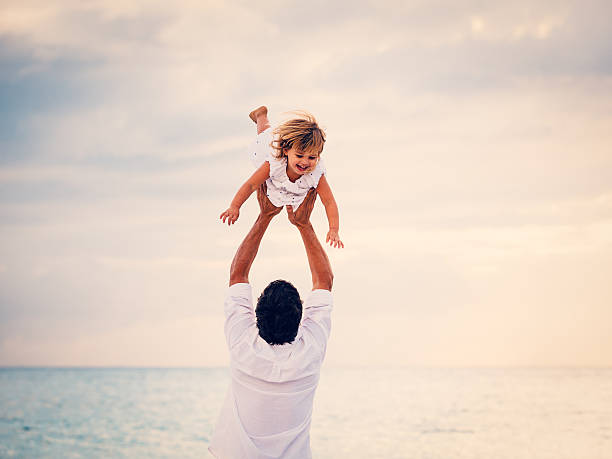 istock Father and Daughter Playing Together at the Beach at Sunset 484328933