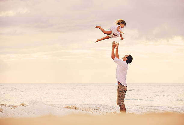 istock Father and Daughter Playing Together at the Beach at Sunset 484328943