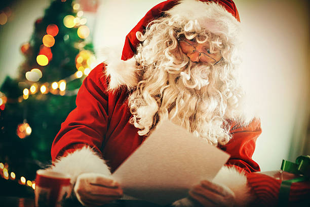 istock Santa Claus reading letters and wishlists. 484329882