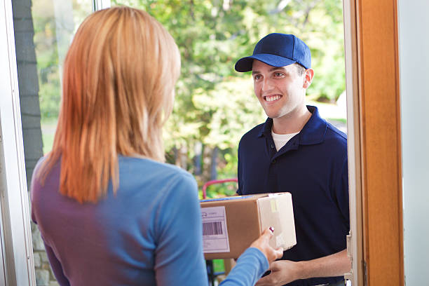 istock Delivery Person Delivering Package Box Container to Home Customer 484330590