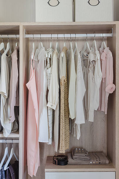 istock clothes hanging in wooden wardrobe 484333858