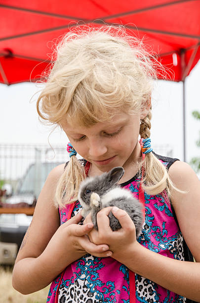 istock girl with young bunny rabbit 484335092