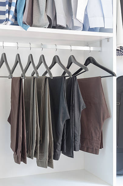 istock pants hanging on rack in wardrobe 484339132