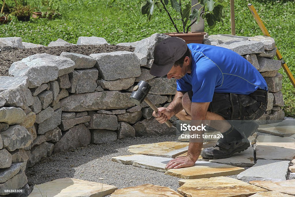 Paver in the garden with marble plates Worker ist paving a place in the garden. Stone - Object Stock Photo