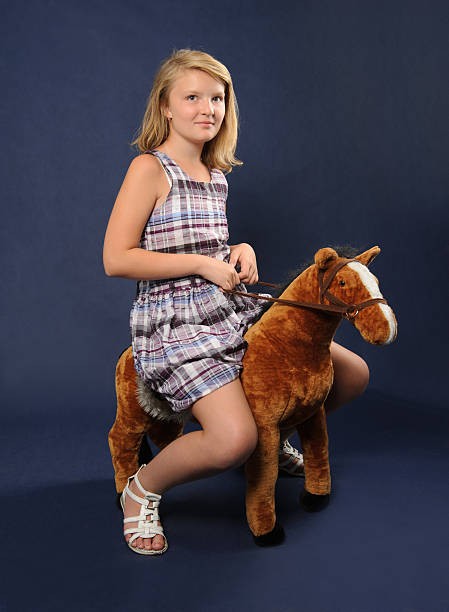 istock Girl riding toy horse 484344389